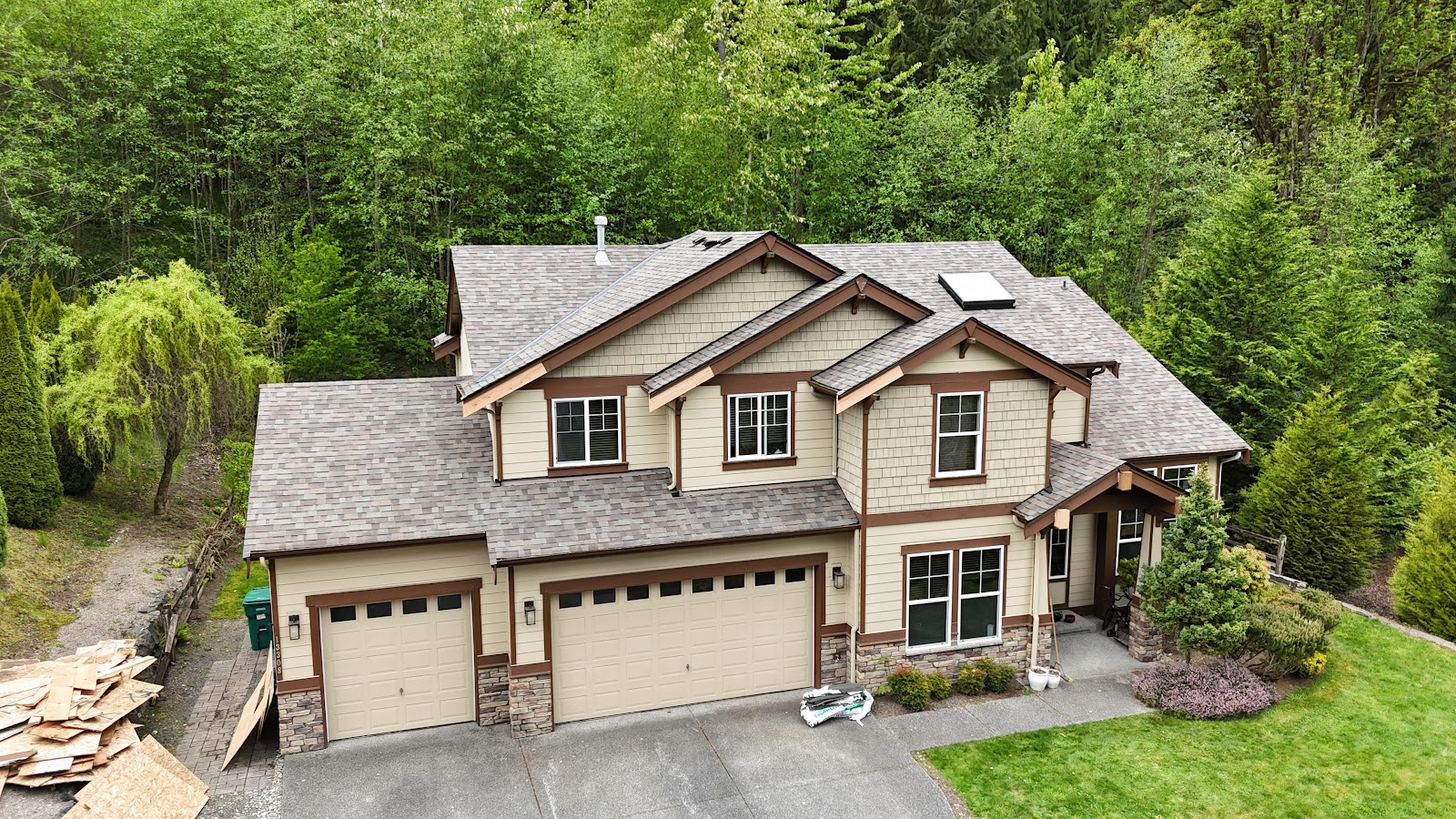 New shingle roof on a large craftsman home surrounded by trees